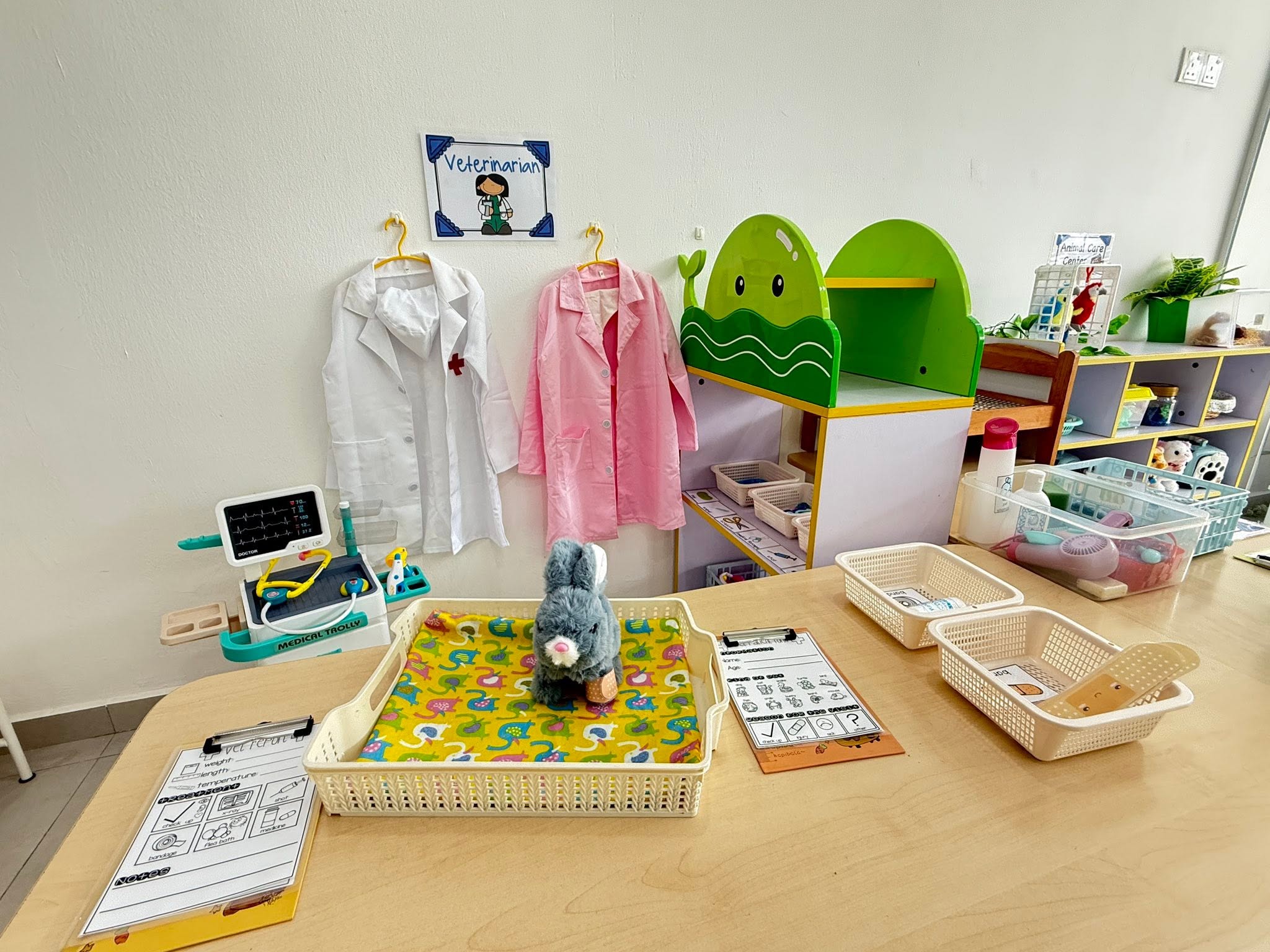Veterinarian role play station with lab coats and medical trolley